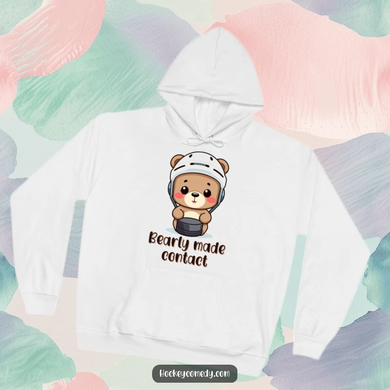 Funny bear in a hockey helmet comically misses a puck on a soft, cozy hoodie.