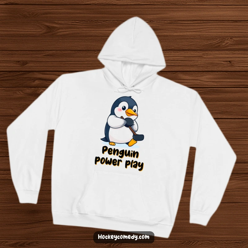 Funny determined penguin hockey hoodie, showing a penguin focused on batting a puck with its beak for the win.
