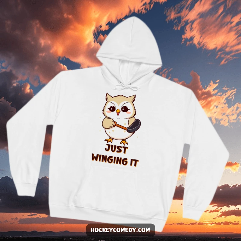 Funny Hoodie with a giggling owl comically attempting to snag a hockey puck with its beak, perfect for cozy, humorous wear.