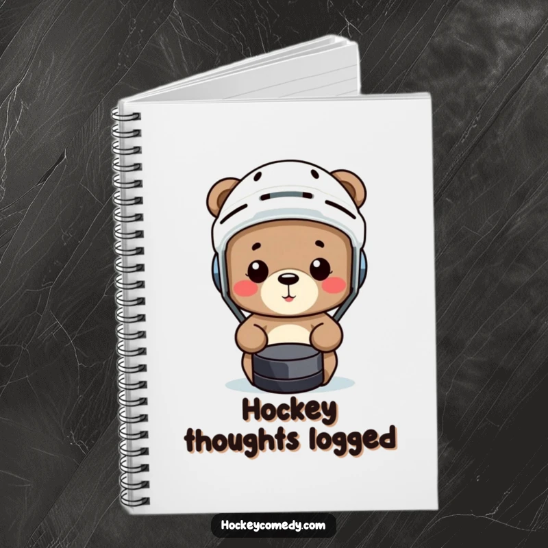 Funny bear wearing a hockey helmet comically misses a puck on the cover of a humorous notebook.
