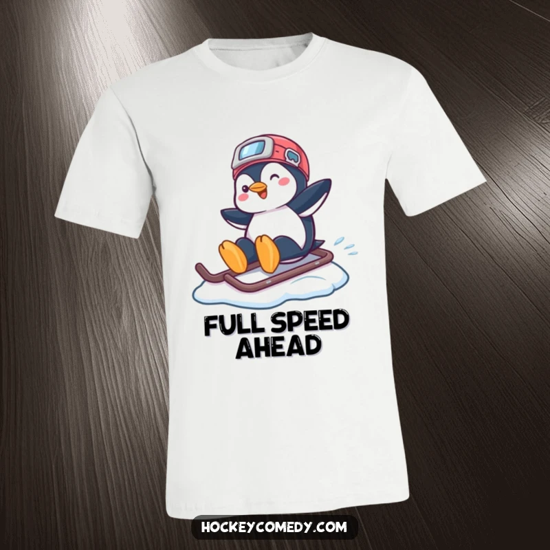 Funny T-shirt illustrating a playful penguin gracefully sliding across ice atop a hockey helmet with a happy expression.