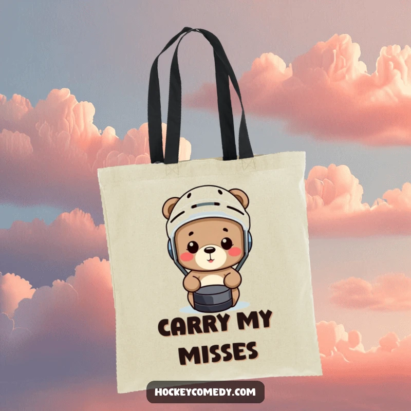 Funny bear wearing a hockey helmet comically misses a puck on a humorous sports tote bag.